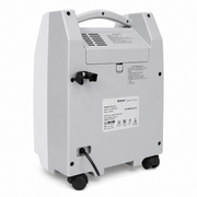 A light gray portable oxygen concentrator shown from the back, featuring a top handle, black wheels, a power cord, and a white model label on a clean white background.