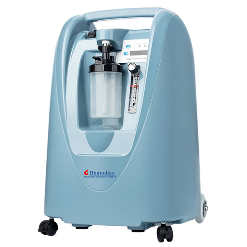 A light blue Hemediaz portable oxygen concentrator with a clear gas reservoir, flow meter, and black caster wheels, shown on a solid white background.