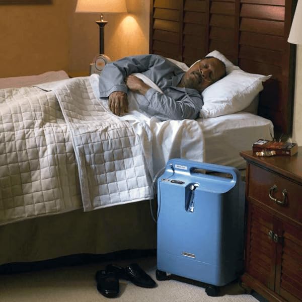Philips EverFlo oxygen concentrator set up in a home care room for continuous respiratory therapy